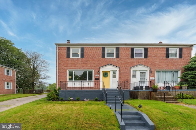 6842 Queens Ferry Rd, Baltimore, MD 21239 - view of front of home with a chimney, brick siding, and a front lawn