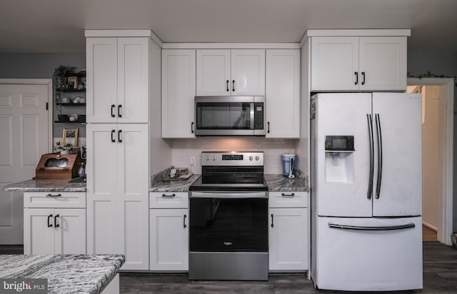 kitchen with dark wood-style floors, white cabinets, light stone countertops, and stainless steel appliances