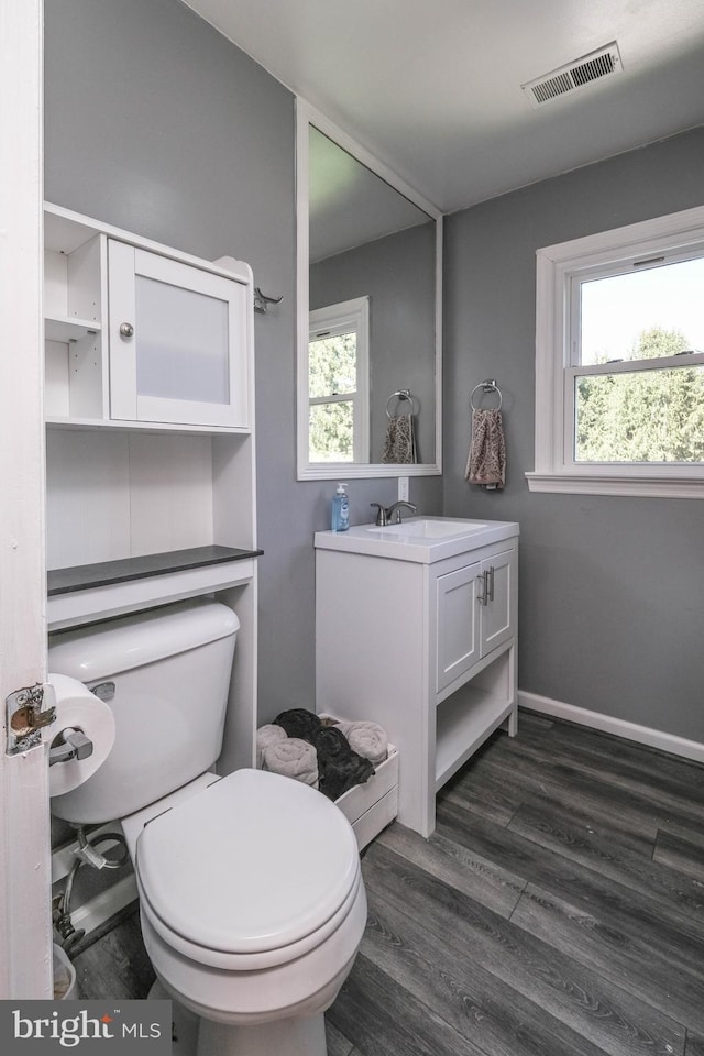 bathroom featuring visible vents, plenty of natural light, wood finished floors, and vanity