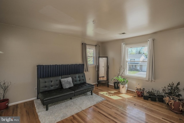 sitting room featuring baseboards, visible vents, and wood finished floors