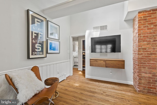 2006 Scroggins Rd, Alexandria, VA 22302 - living area with a baseboard heating unit, visible vents, and wood finished floors