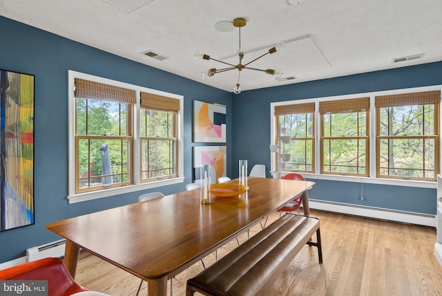 2006 Scroggins Rd, Alexandria, VA 22302 - dining area featuring a baseboard radiator, a chandelier, a textured ceiling, and visible vents