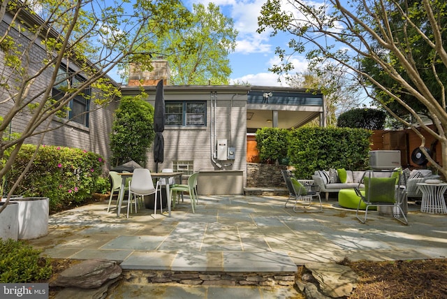 2006 Scroggins Rd, Alexandria, VA 22302 - rear view of house featuring fence, outdoor dining space, outdoor lounge area, a chimney, and a patio area