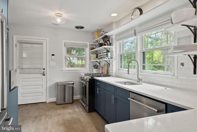 2006 Scroggins Rd, Alexandria, VA 22302 - kitchen featuring open shelves, a sink, light wood finished floors, stainless steel appliances, and decorative backsplash