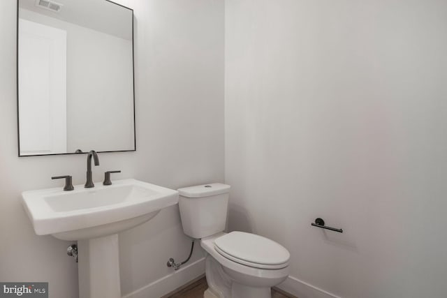 bathroom featuring visible vents, toilet, and baseboards