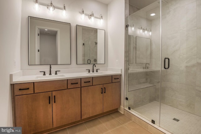 bathroom with a stall shower, tile patterned flooring, a sink, and double vanity