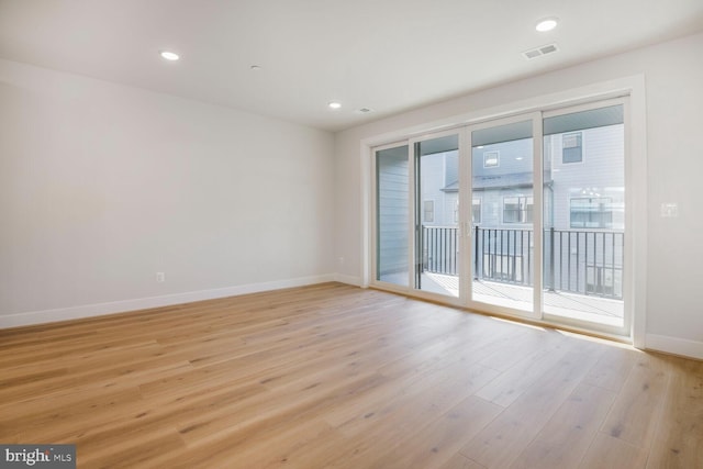 empty room with baseboards, visible vents, light wood finished floors, and recessed lighting