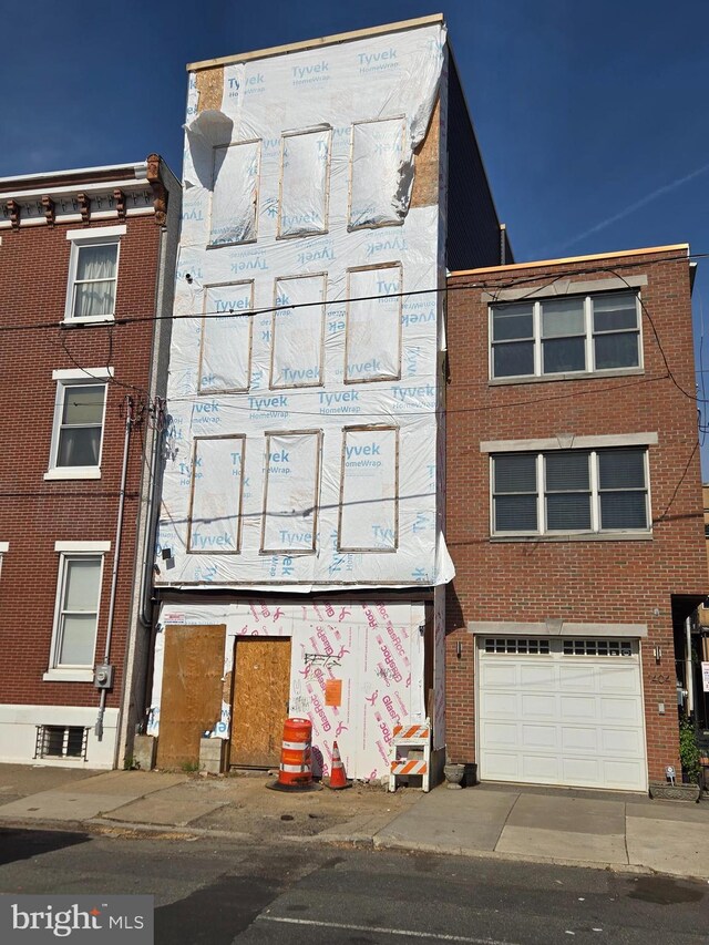 1406 E Moyamensing Ave, Philadelphia, PA 19147 - view of front of home featuring brick siding and a garage