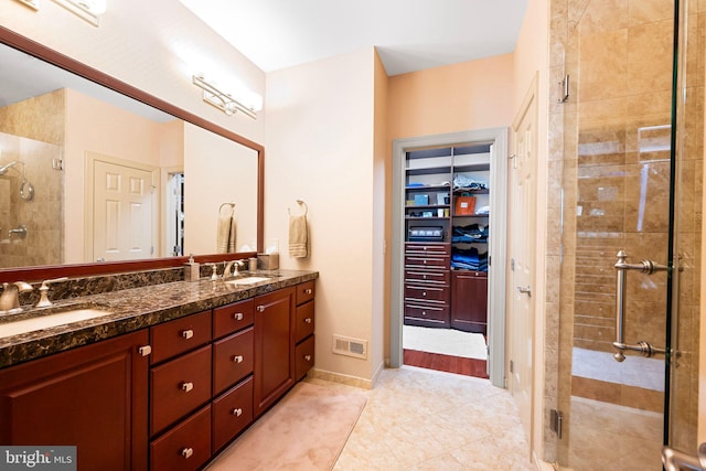 full bath featuring visible vents, tile patterned flooring, double vanity, a shower stall, and a sink