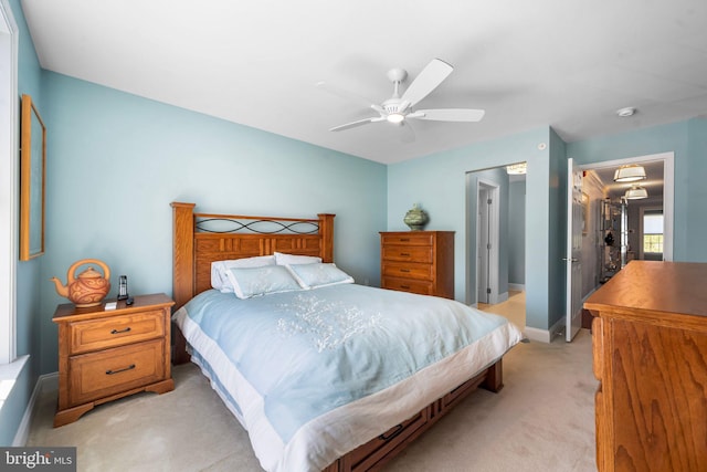 bedroom with baseboards, ceiling fan, and light carpet