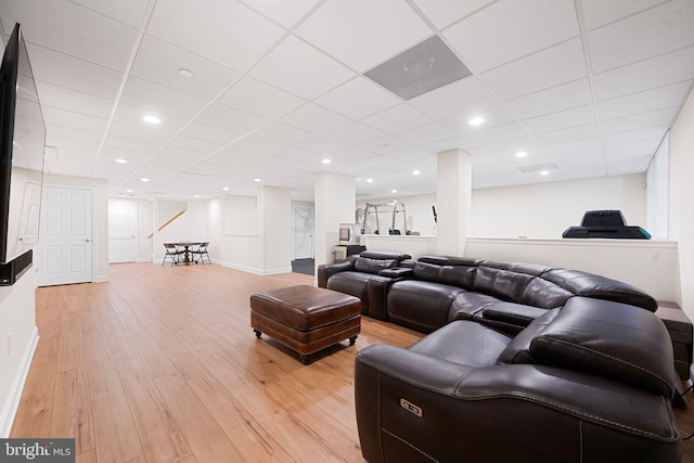 living area featuring recessed lighting, baseboards, a drop ceiling, and light wood-style flooring
