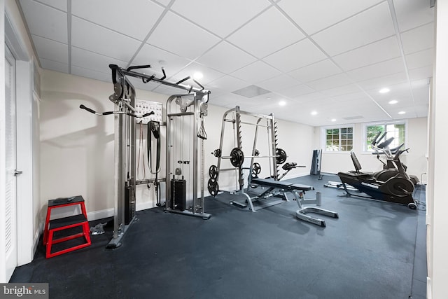 workout area with baseboards, recessed lighting, and a paneled ceiling