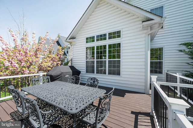 wooden deck featuring grilling area and outdoor dining space