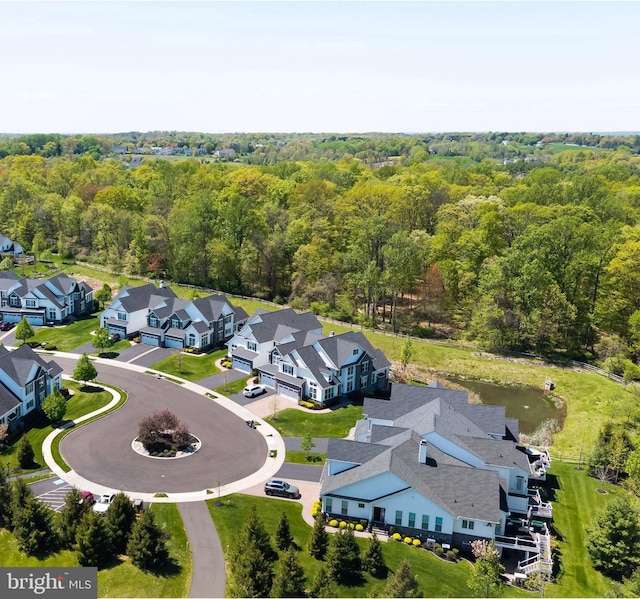 drone / aerial view featuring a residential view and a forest view