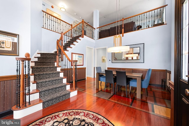stairway featuring wood-type flooring and a high ceiling