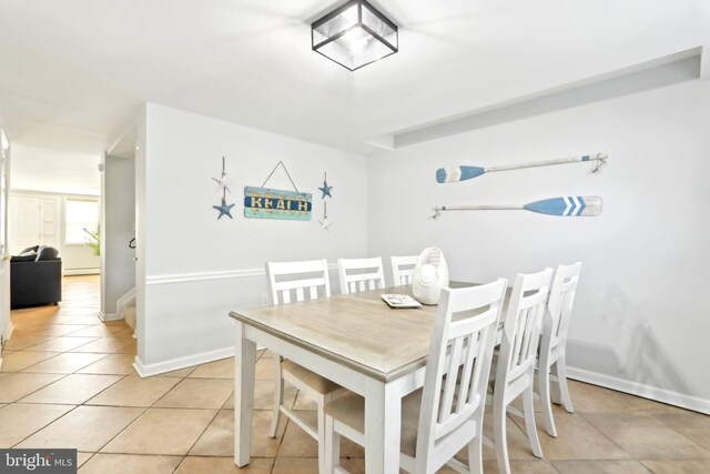 dining space featuring light tile patterned floors and baseboards