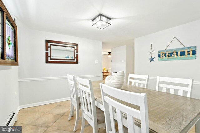 dining room with baseboards, light tile patterned floors, and a baseboard radiator