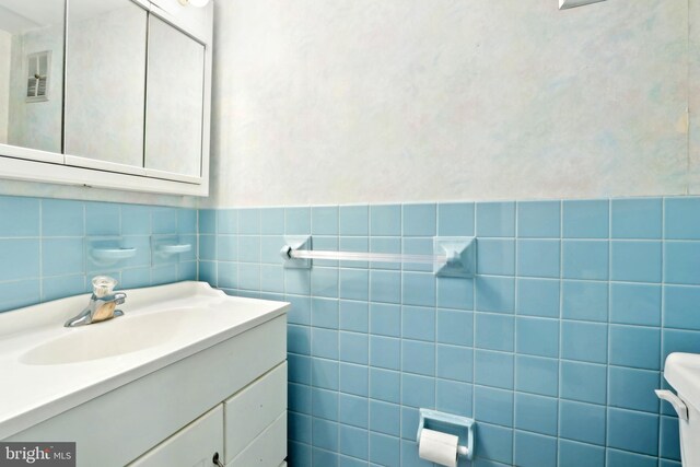 bathroom featuring visible vents, toilet, and vanity