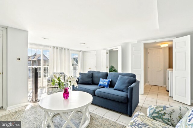 living area featuring baseboards and light tile patterned floors