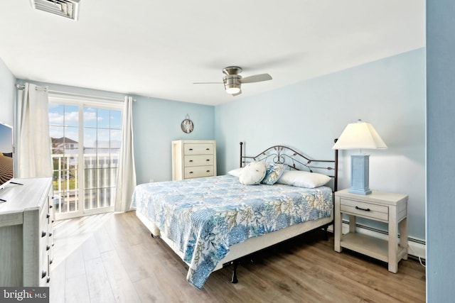 bedroom with wood finished floors, visible vents, and a ceiling fan