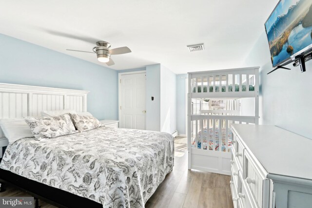 bedroom featuring visible vents, a ceiling fan, and light wood-style floors