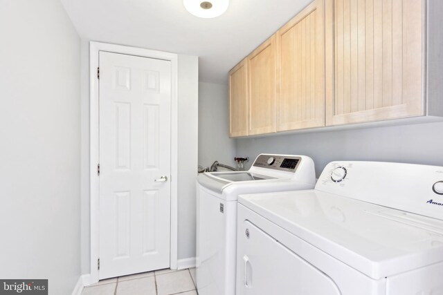 washroom featuring light tile patterned floors, washer and dryer, cabinet space, and baseboards