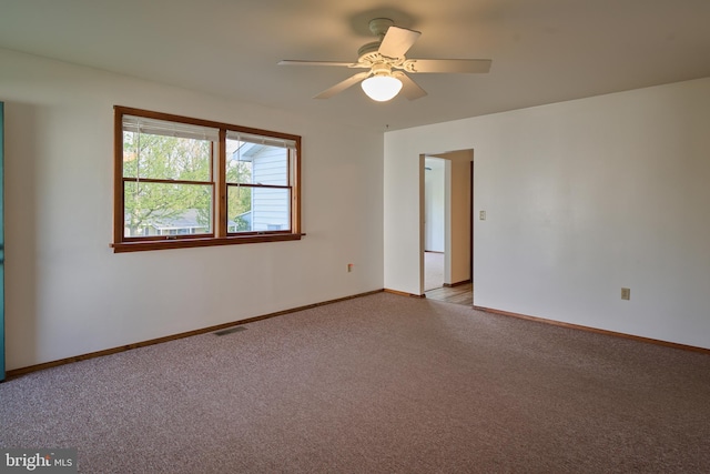 unfurnished room with baseboards, visible vents, light carpet, and ceiling fan