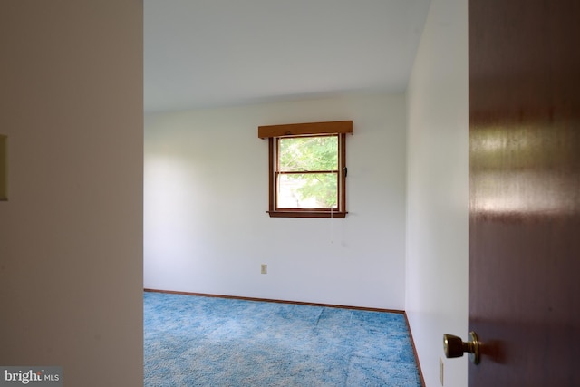carpeted spare room featuring baseboards
