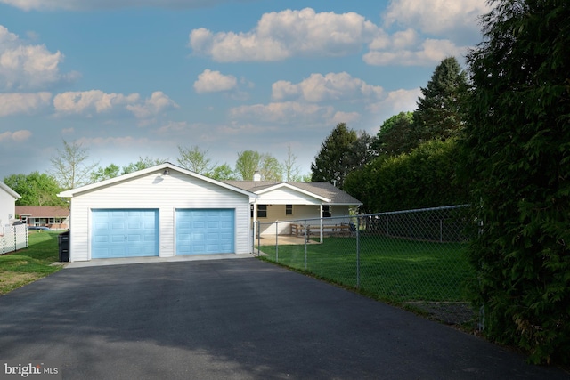 ranch-style house with fence private yard, a front lawn, and a detached garage
