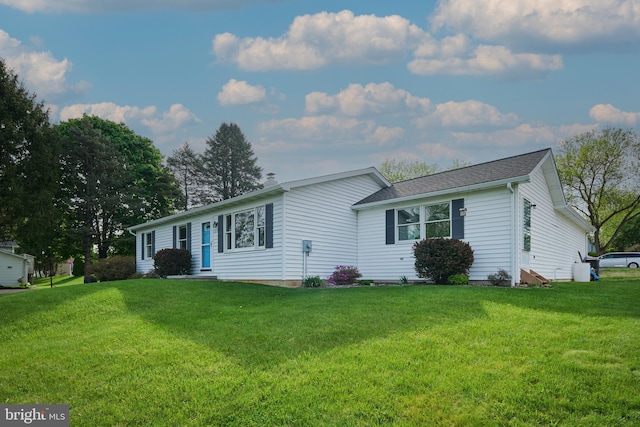 ranch-style house featuring entry steps and a front lawn