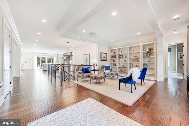 sitting room featuring an upstairs landing, crown molding, visible vents, a chandelier, and hardwood / wood-style flooring