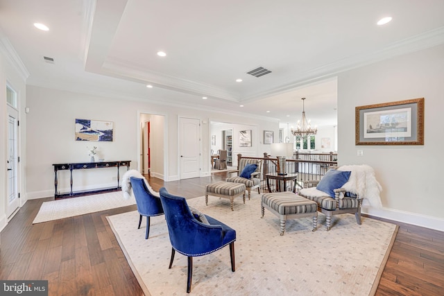 living room featuring baseboards, ornamental molding, an inviting chandelier, visible vents, and dark wood-type flooring
