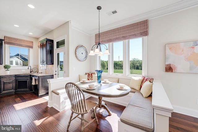 dining area with crown molding, dark wood-style flooring, baseboards, and visible vents