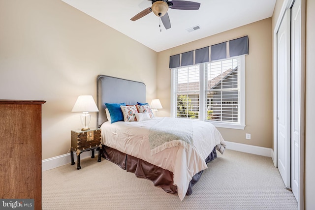 carpeted bedroom featuring baseboards, visible vents, and a ceiling fan