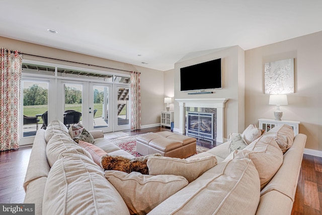 living room with baseboards, dark wood-style flooring, french doors, and a fireplace