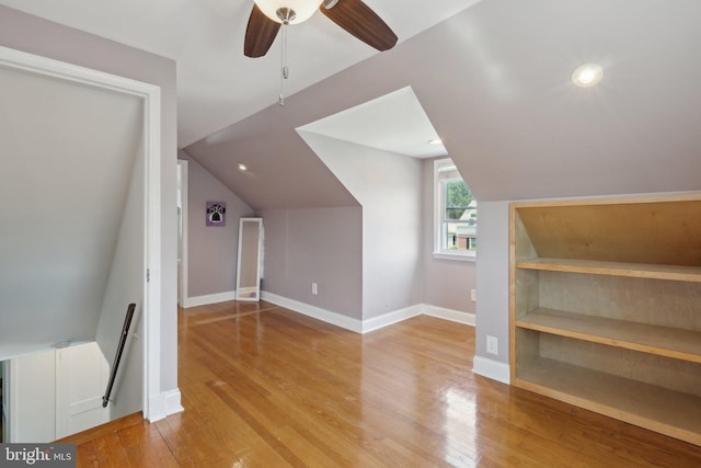 bonus room featuring baseboards, ceiling fan, vaulted ceiling, and light wood-style flooring