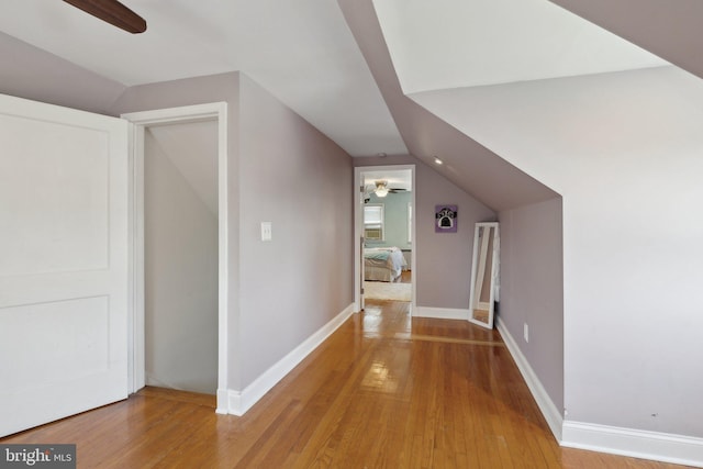 bonus room with vaulted ceiling, baseboards, a ceiling fan, and light wood-type flooring