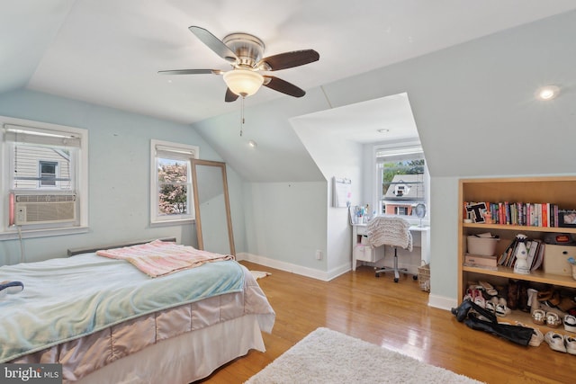 bedroom with wood finished floors, lofted ceiling, baseboards, cooling unit, and a ceiling fan