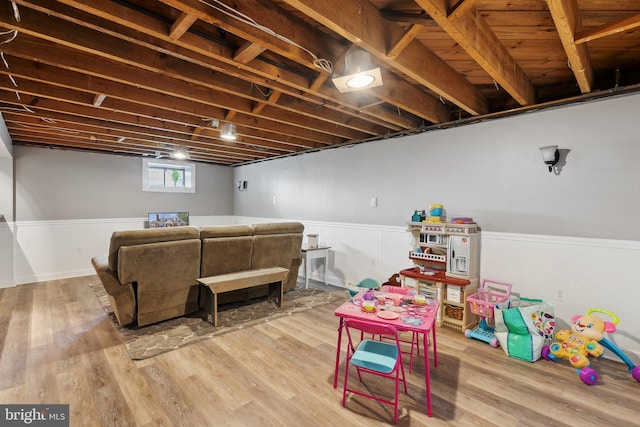 recreation room with a wainscoted wall and wood finished floors