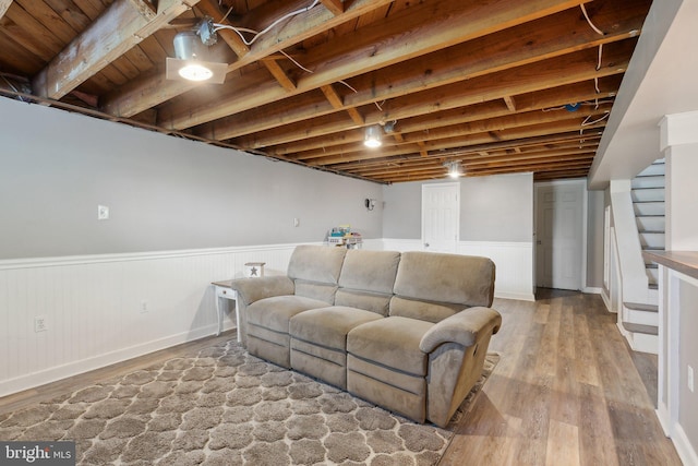 living area featuring stairway, wainscoting, and wood finished floors