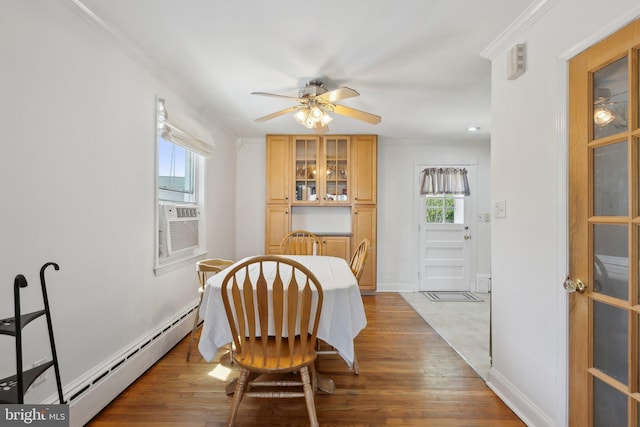 dining room with a ceiling fan, wood finished floors, baseboards, cooling unit, and a baseboard heating unit