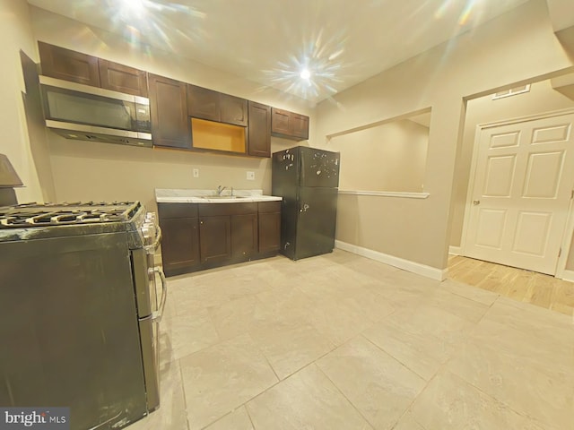 2138 N 18th St, Philadelphia, PA 19121 - kitchen with light countertops, dark brown cabinetry, appliances with stainless steel finishes, and baseboards