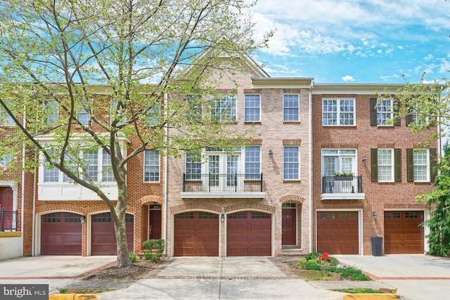 multi unit property featuring brick siding, an attached garage, and driveway
