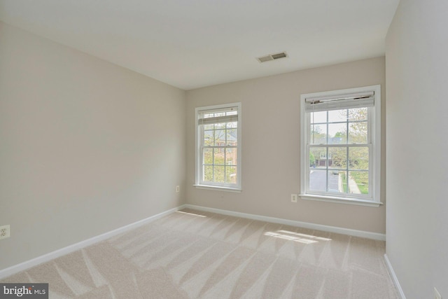 spare room featuring visible vents, baseboards, and a wealth of natural light