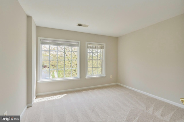 empty room featuring baseboards, carpet flooring, and visible vents