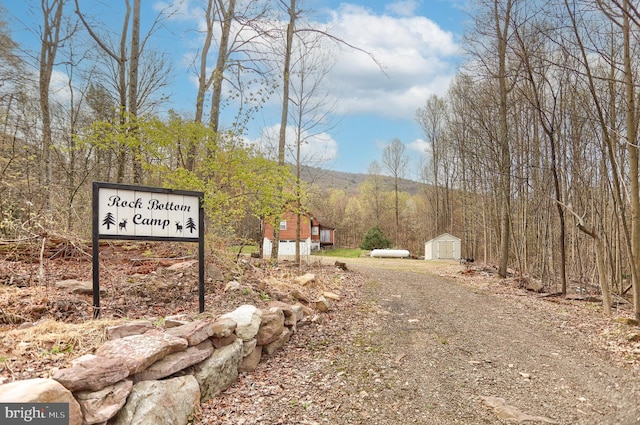 view of street featuring a view of trees and driveway