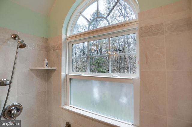 full bath with vaulted ceiling and tiled shower