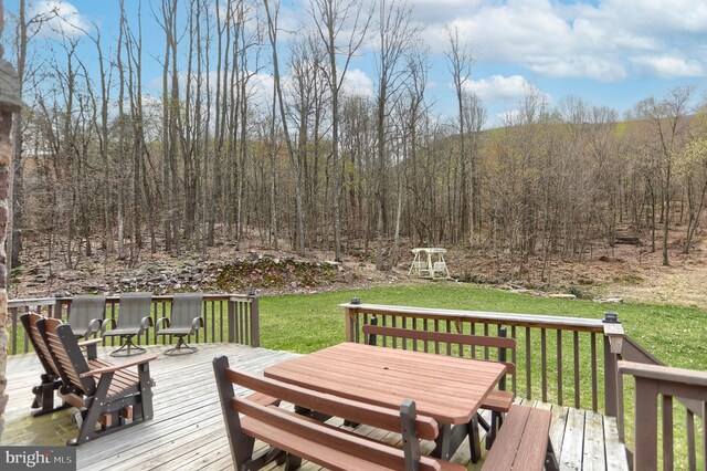 deck with a lawn and outdoor dining space