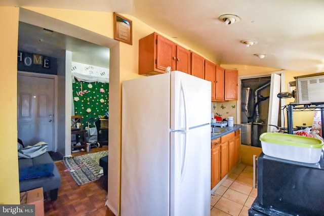 1921 Rhode Island Ave NE, Washington, DC 20018 - kitchen featuring a sink, dark countertops, vaulted ceiling, freestanding refrigerator, and light tile patterned floors