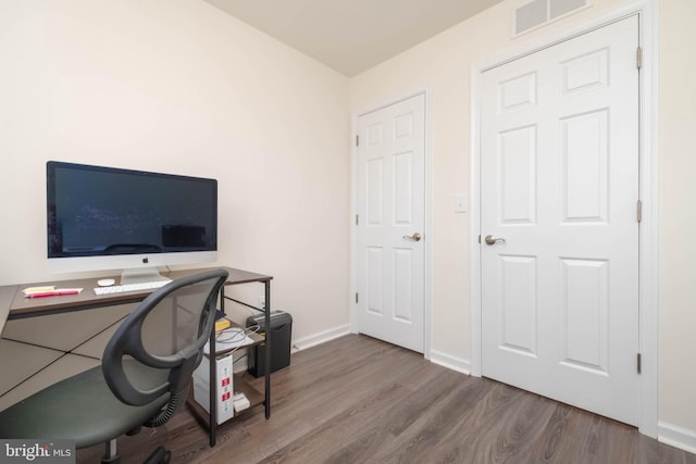 office area with visible vents, baseboards, and wood finished floors